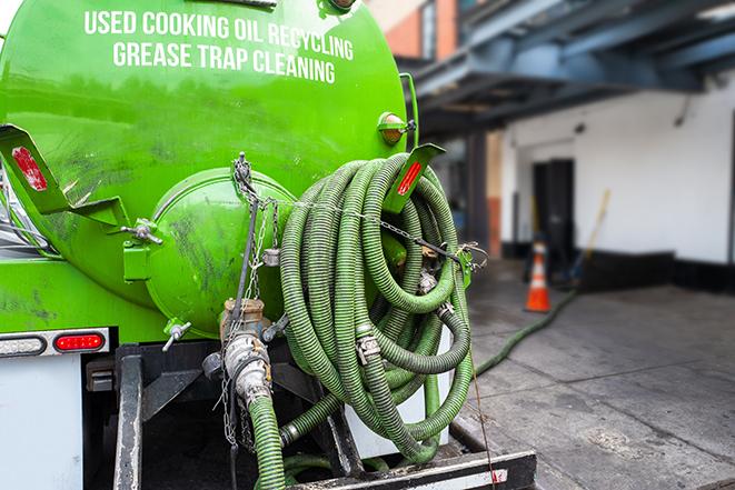 a technician pumping a grease trap in a commercial building in Laguna Woods